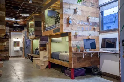 a room with a bed and a desk with a computer at PodShare East Hollywood in Los Angeles