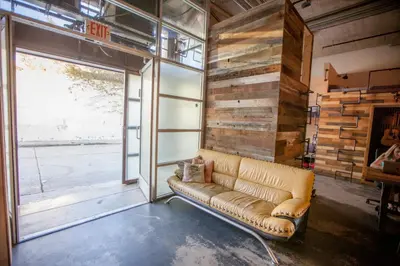 a leather couch in a room with a large window at PodShare Hollywood in Los Angeles