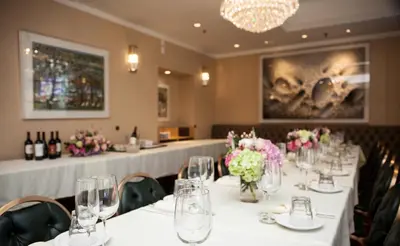 a long table in a room with white tables and flowers at Olyver Hotel in Los Angeles