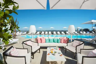 a patio with a couch and chairs and a pool at Waldorf Astoria Beverly Hills in Los Angeles