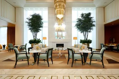 a lobby with tables and chairs and a fireplace at Waldorf Astoria Beverly Hills in Los Angeles