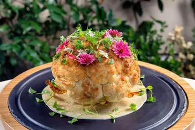 a cake with flowers on top of it on a plate at Waldorf Astoria Beverly Hills in Los Angeles