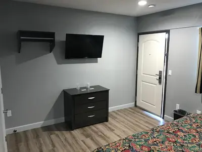 a bedroom with a dresser and a tv on the wall at Empire Inn in Los Angeles