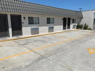 a building with a row of doors in a parking lot at Empire Inn in Los Angeles