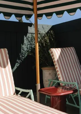 two chairs and a table under an umbrella at Le Petit Pali Brentwood in Los Angeles