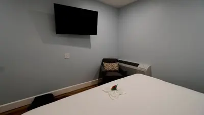 a room with a bed and a tv on the wall at El Royale Gardens Near Universal Studios in Los Angeles