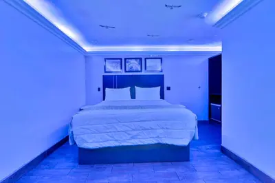 a bedroom with a large bed with blue lights at Mid City Inn in Los Angeles