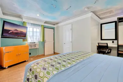 a bedroom with a bed and a tv on the wall at Mid City Inn in Los Angeles