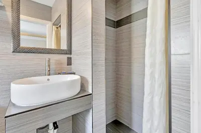 a bathroom with a sink and a mirror at Mid City Inn in Los Angeles