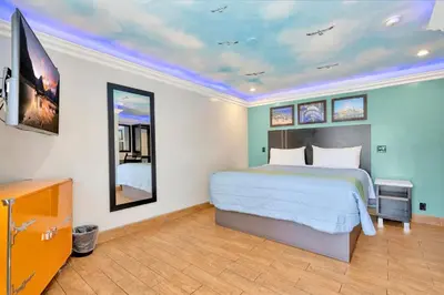 a bedroom with a bed and a tv in it at Mid City Inn in Los Angeles