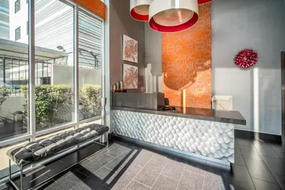 a lobby with a waiting area with benches and windows at Lexen Hotel - Hollywood Walk of Fame-Universal Studios in Los Angeles