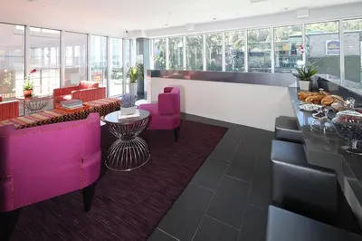 a lobby with purple chairs and a table in a building at Lexen Hotel - Hollywood Walk of Fame-Universal Studios in Los Angeles
