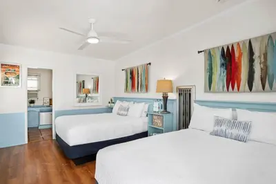 two beds in a room with blue and white at Sea Blue Hotel in Los Angeles