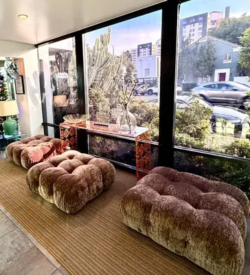 a room with three ottomans in front of a large window at Park Plaza Lodge in Los Angeles