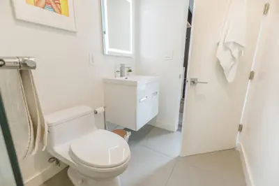 a white bathroom with a toilet and a sink at Park Plaza Lodge in Los Angeles