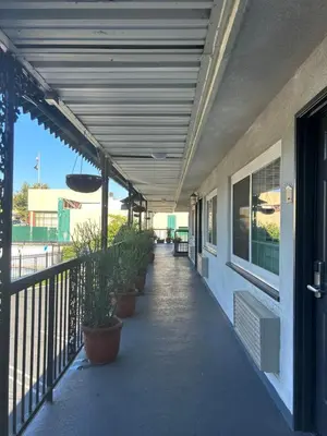a covered walkway with potted plants on a building at Welcome Inn in Los Angeles