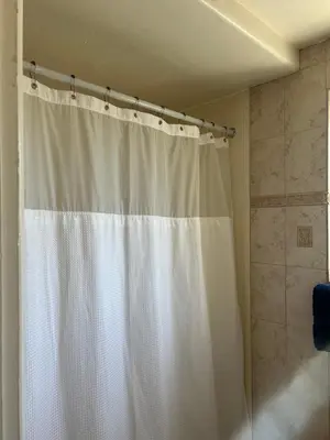 a white shower curtain in a bathroom with a tub at Welcome Inn in Los Angeles