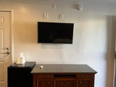 a flat screen tv on the wall of a room at Welcome Inn in Los Angeles
