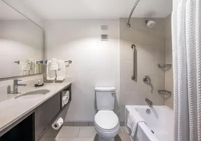 a bathroom with a toilet and a tub and a sink at Holiday Inn Oxnard - Ventura by IHG in Oxnard