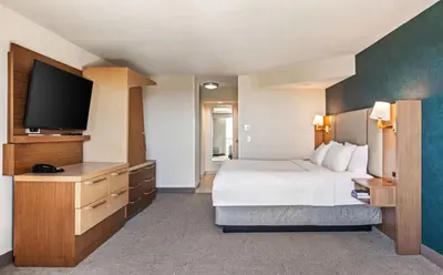 a hotel room with a bed and a flat screen tv at Holiday Inn Oxnard - Ventura by IHG in Oxnard