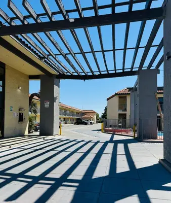 an empty parking lot with awning over a building at Baymont by Wyndham Bakersfield in Bakersfield