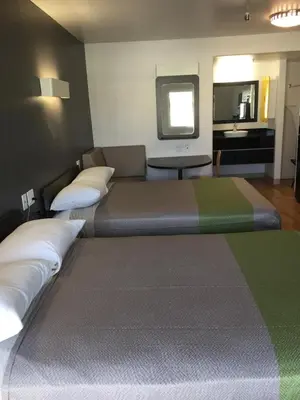 a large bed in a room with a couch at Studio 6 Victorville - Apple Valley in Victorville