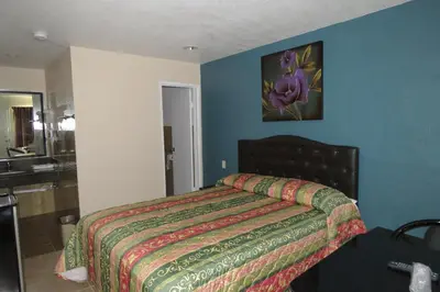 a bedroom with a bed and a bathroom with a sink at Florentina Motel - Los Angeles in Los Angeles