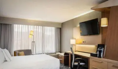 a hotel room with a bed and a desk and a television at Courtyard by Marriott Riverside UCR/Moreno Valley Area in Riverside