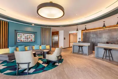 a lobby of a hotel with chairs and a bar at Cambria Hotel LAX in El Segundo