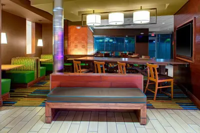 a restaurant with a bench and a table and chairs at Fairfield Inn & Suites by Marriott Bakersfield North/Airport in Bakersfield
