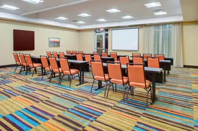 a conference room with tables and chairs and a screen at Fairfield Inn & Suites by Marriott Bakersfield North/Airport in Bakersfield