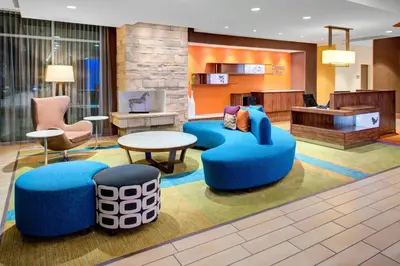 a lobby with blue seats and a table and chairs at Fairfield Inn & Suites by Marriott Bakersfield North/Airport in Bakersfield