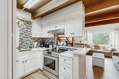 a kitchen with white cabinets and a stove top oven at Sugar Shack in Carpinteria