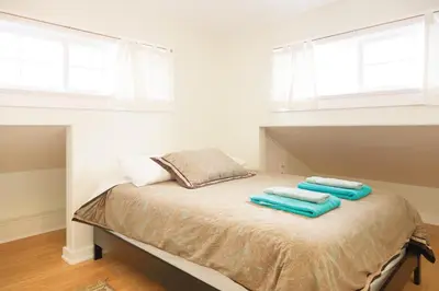 a bedroom with a bed with two towels on it at Orange Drive Hostel in Los Angeles