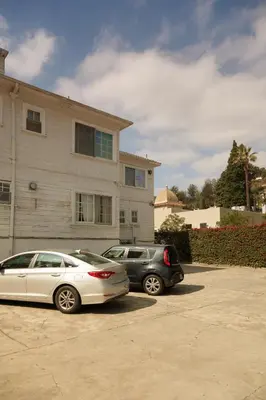 two cars parked in a parking lot in front of a house at Orange Drive Hostel in Los Angeles