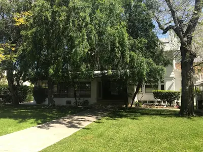 a white house with trees in the yard at Orange Drive Hostel in Los Angeles
