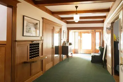 a hallway with a living room with a green carpet at Orange Drive Hostel in Los Angeles