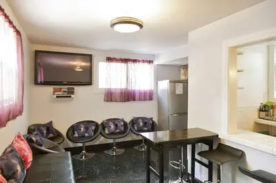 a living room with a table and chairs and a television at Orange Drive Hostel in Los Angeles