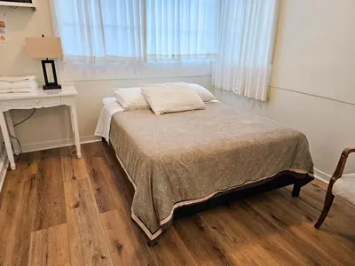a bedroom with a bed and a table and a window at Orange Drive Hostel in Los Angeles