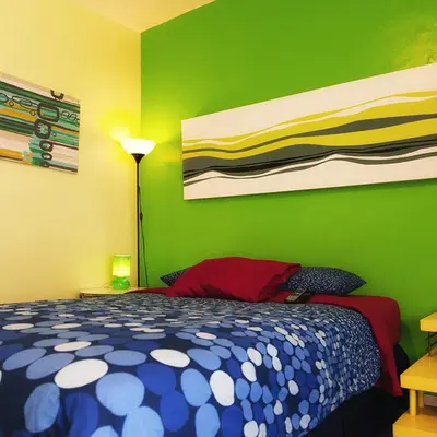 a bedroom with a bed and a green wall at Banana Bungalow West Hollywood Hotel & Hostel in Los Angeles