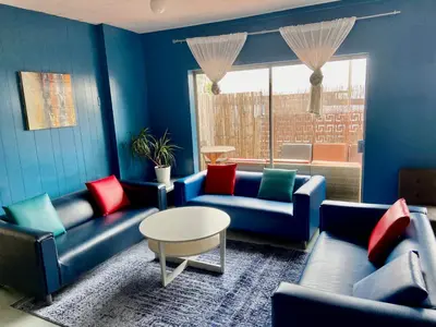 a blue living room with couches and a table at Banana Bungalow West Hollywood Hotel & Hostel in Los Angeles