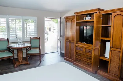 a room with a table and a tv and a entertainment center at Casa Ojai Inn in Ojai