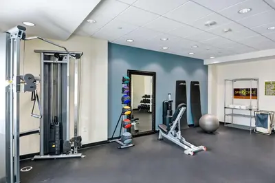 a gym with several tread machines and a mirror at Home2 Suites Azusa in Azusa