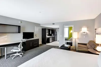 a hotel room with a bed and a desk at Home2 Suites Azusa in Azusa