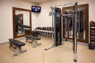 a gym with a bunch of weights and mirrors at DoubleTree by Hilton Rosemead in Rosemead