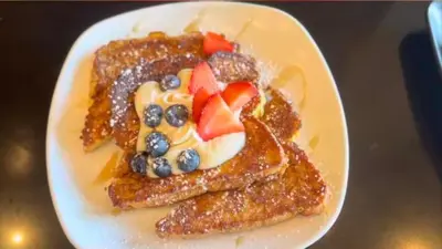 a plate of french toast with fruit and syrup at DoubleTree by Hilton Rosemead in Rosemead