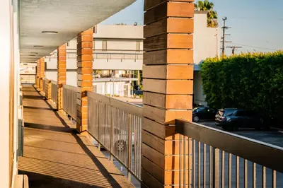 a balcony with a fence and a car on a street at Gateway Inn Gardena Los Angeles South in Gardena