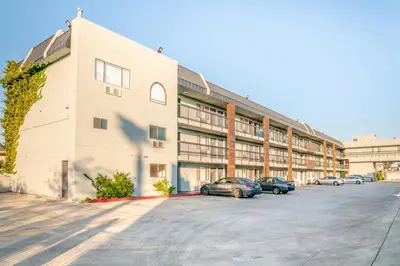 a large building with cars parked in a parking lot at Gateway Inn Gardena Los Angeles South in Gardena