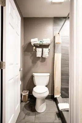 a bathroom with a white toilet and towels at Gateway Inn Gardena Los Angeles South in Gardena