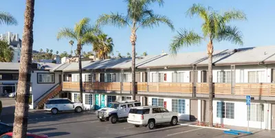 a building with cars parked in a parking lot with palm trees at The Dixie Hollywood in Los Angeles